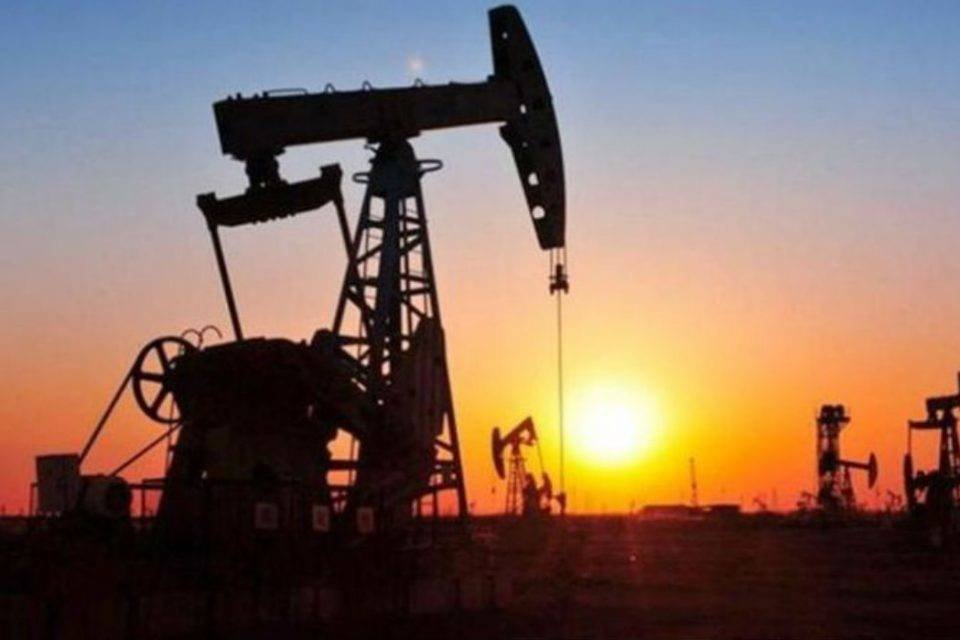 Bombas de extracción petrolera (pumpjacks) en el campo al atardecer.
